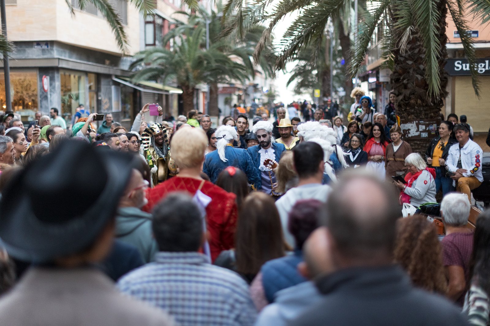 Straßenmusikanten in historischen Kostümen spielen Instrumente und singen mit der Menschenmenge beim Karneval von Las Palmas
