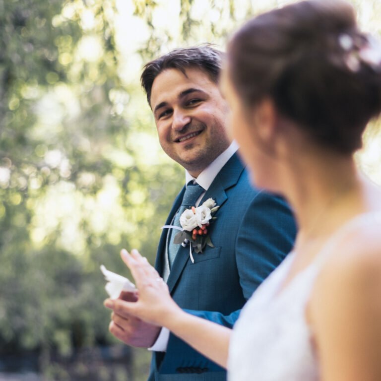 Ein frisch verheiratetes Paar geht bei einem Fotoshooting an einer Kamera vorbei