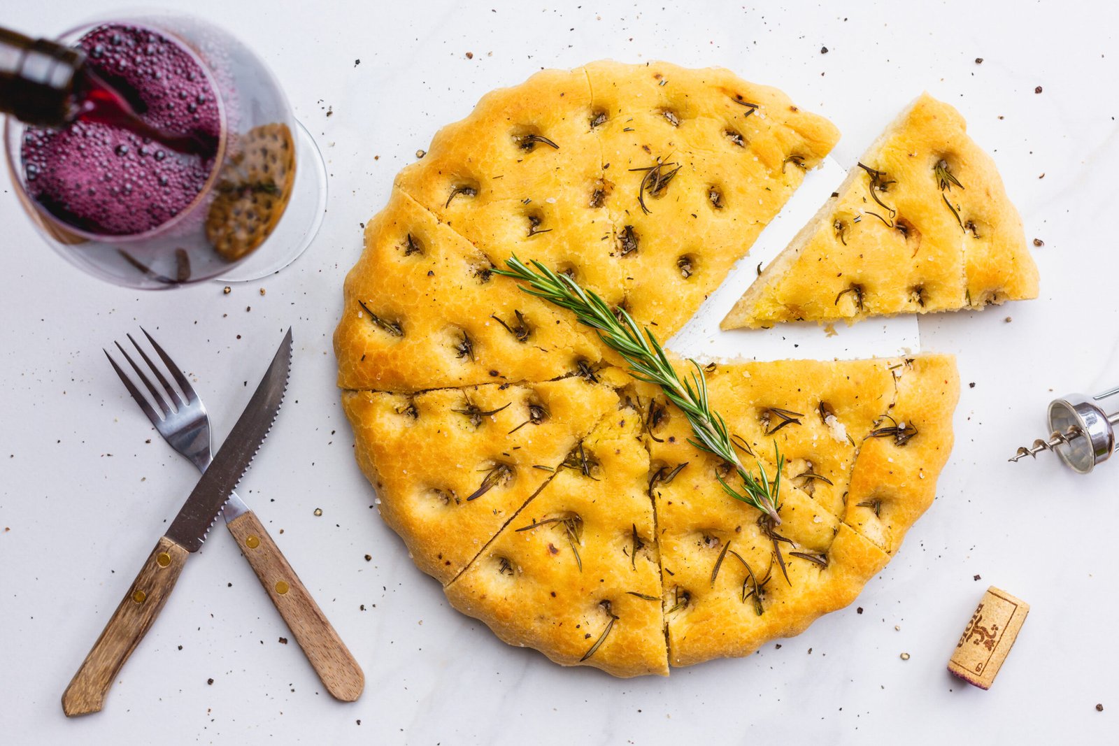 Focaccia mit einer Flasche Rotwein, die in ein Glas gegossen wird